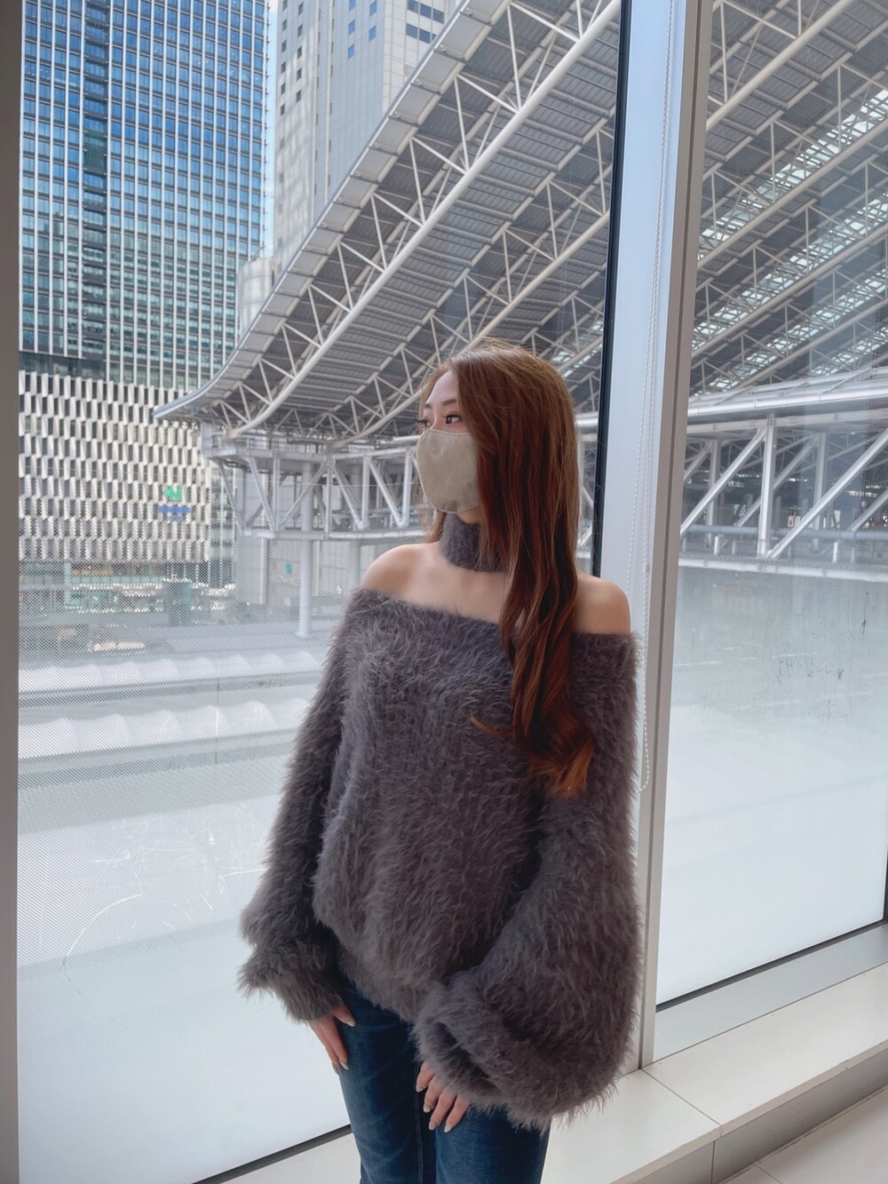 ホワイト系のニット/セーター、ブルー系のデニムパンツ、ホワイト系のパンプスを着用したレディースの冬コーディネートの5枚目の写真