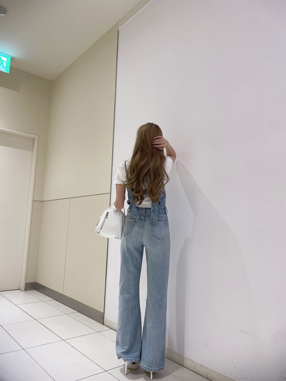 ブルー系のサロペット/オーバーオール、ホワイト系のTシャツ/カットソー、ブラック系のバックパック/リュックを着用したレディースの春コーディネートの3枚目の写真