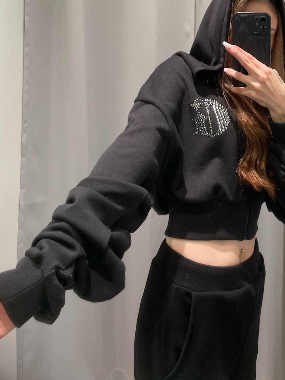 ホワイト系のスニーカー、ブラック系のスウェットパンツ、ブラック系のパーカーを着用したレディースの冬コーディネートの6枚目の写真