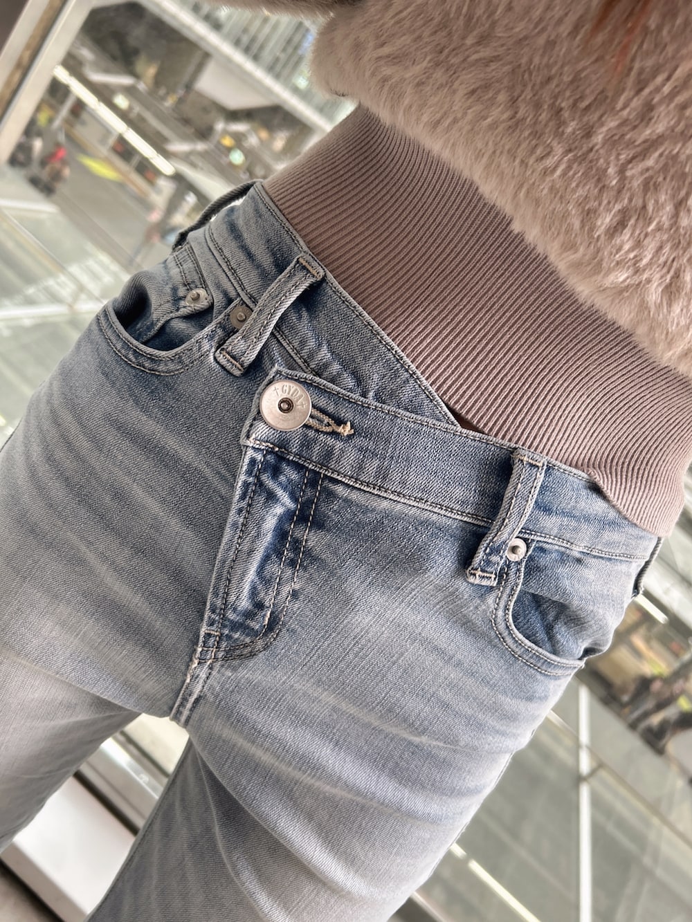 ベージュ系のニット/セーター、ブルー系のデニムパンツ、ブラック系のパンプスを着用したレディースの秋コーディネートの8枚目の写真