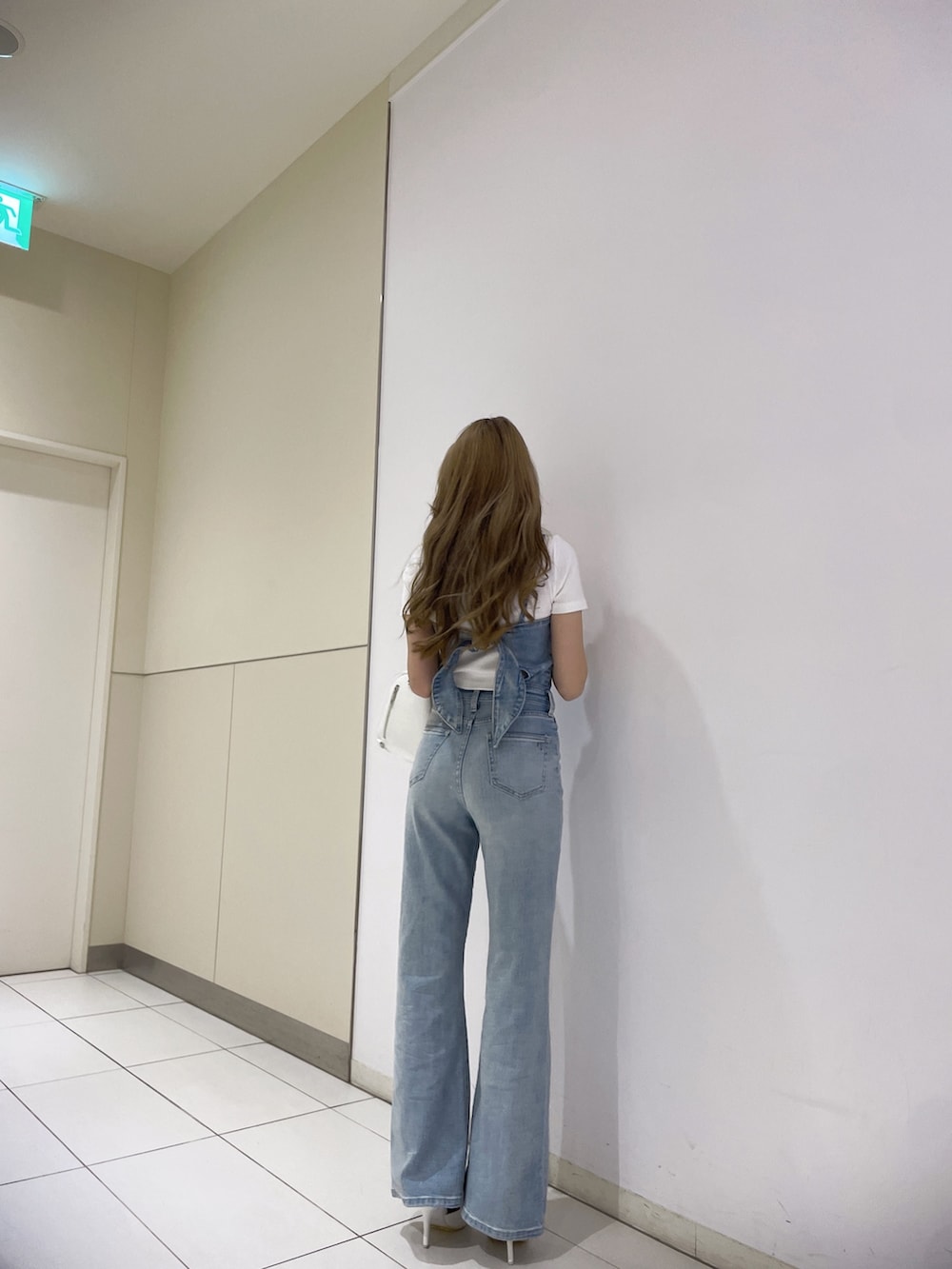 ブルー系のサロペット/オーバーオール、ホワイト系のTシャツ/カットソー、ブラック系のバックパック/リュックを着用したレディースの春コーディネートの4枚目の写真