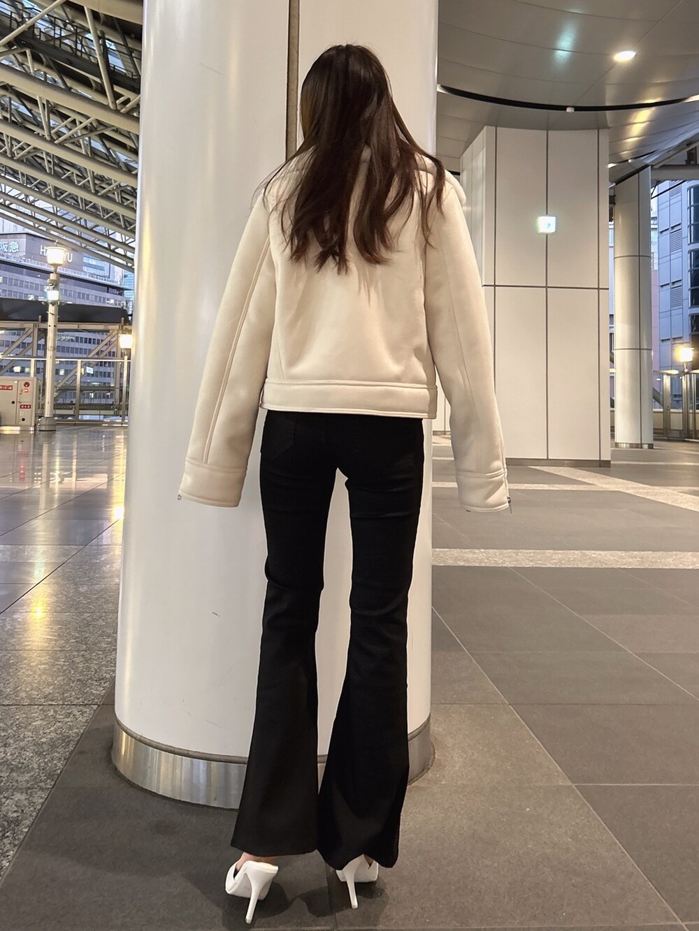 ホワイト系のムートンコート、ホワイト系のニット/セーター、ブラック系のデニムパンツを着用したレディースの秋コーディネートの2枚目の写真