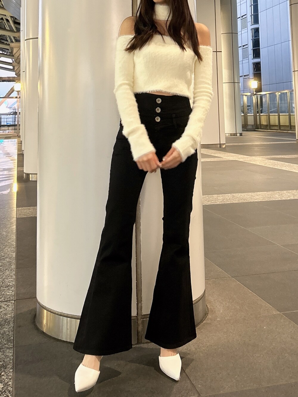 ホワイト系のムートンコート、ホワイト系のニット/セーター、ブラック系のデニムパンツを着用したレディースの秋コーディネートの6枚目の写真