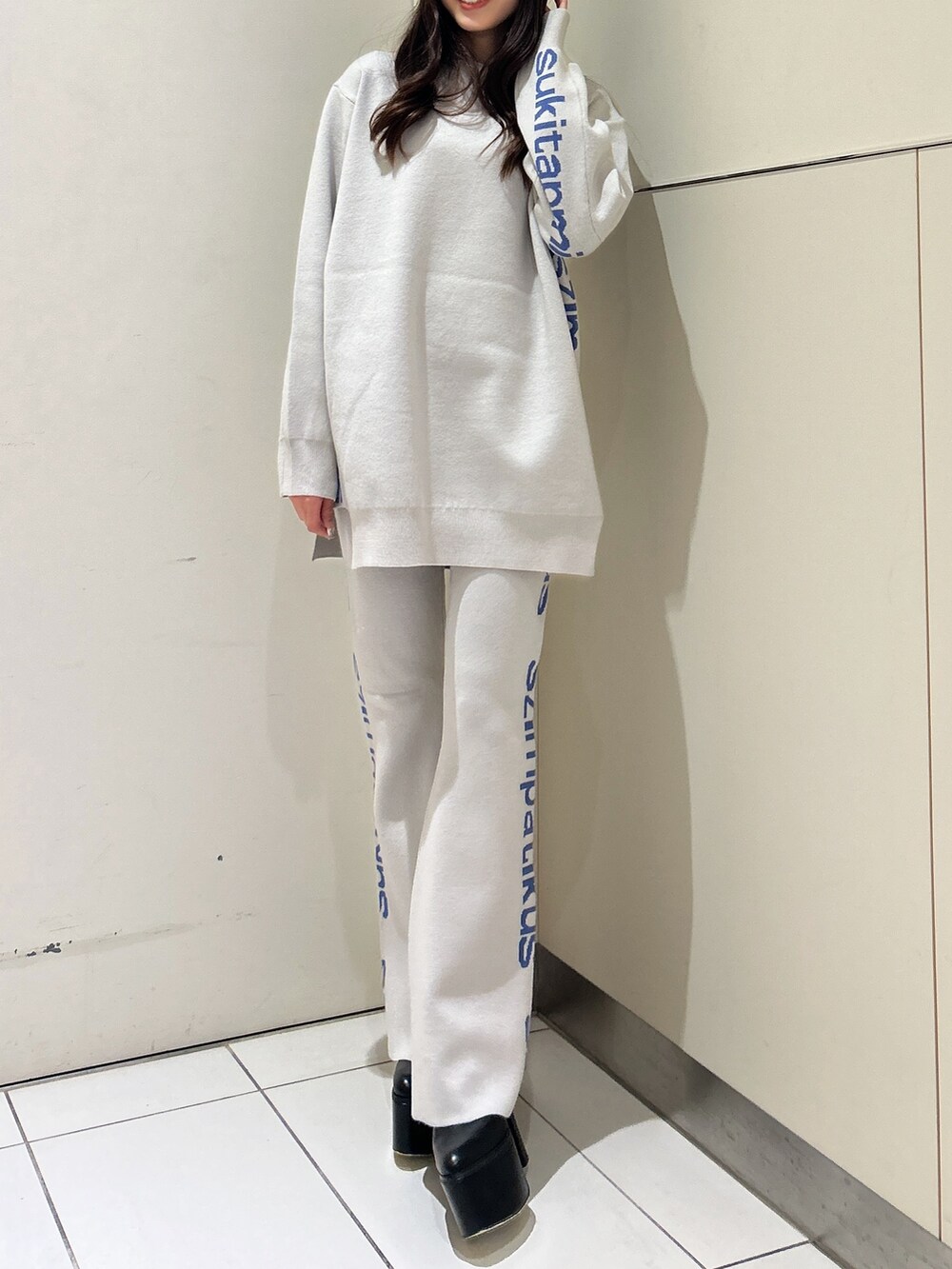ホワイト系のニット/セーター、オレンジ系のその他パンツ、ブラック系のブーツを着用したレディースの冬コーディネートの2枚目の写真