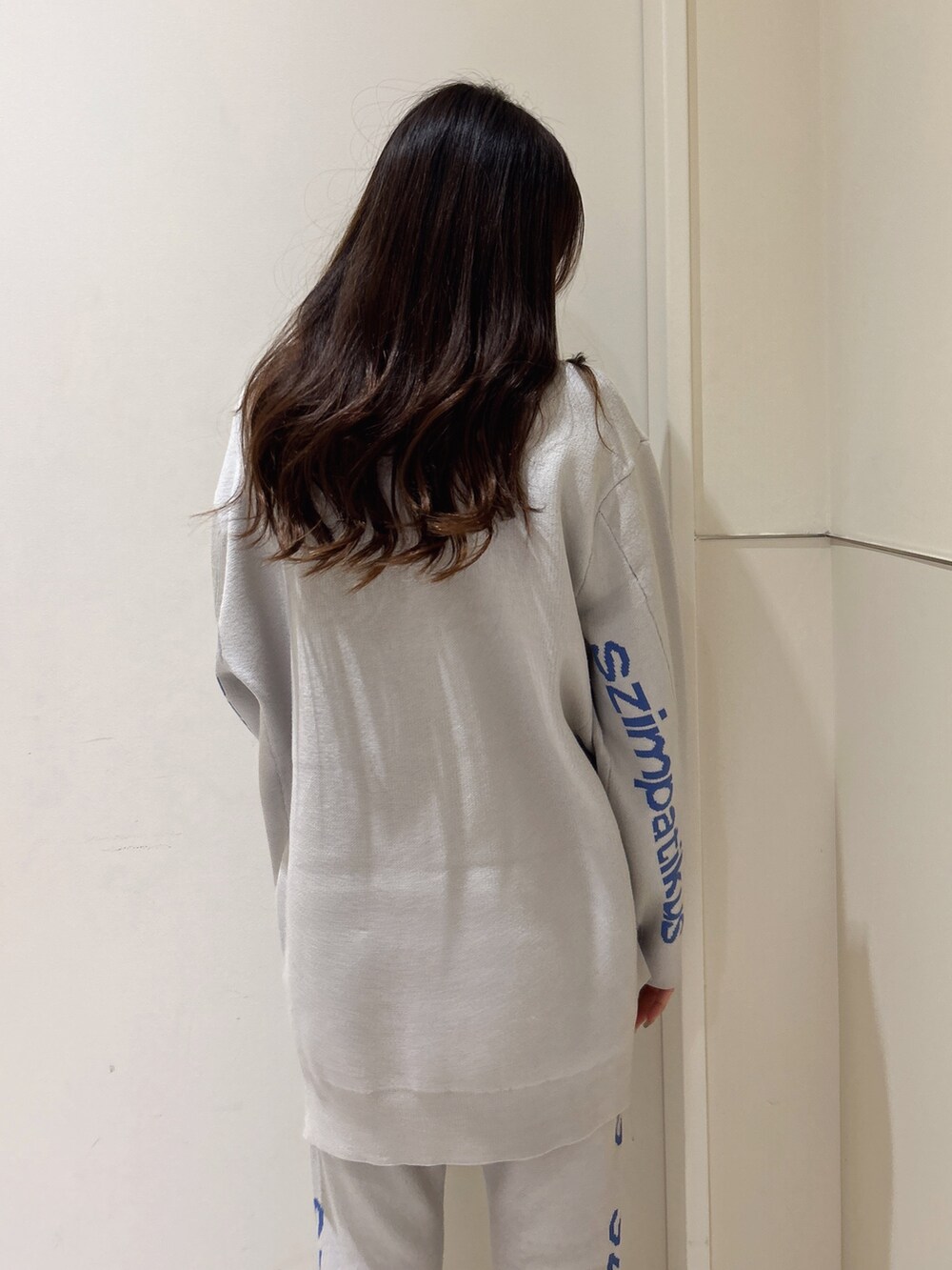 ホワイト系のニット/セーター、オレンジ系のその他パンツ、ブラック系のブーツを着用したレディースの冬コーディネートの5枚目の写真