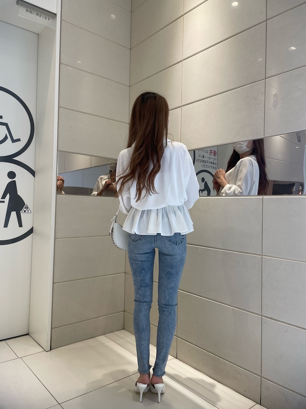 ホワイト系のシャツ/ブラウス、ブルー系のデニムパンツ、ホワイト系のパンプスを着用したレディースの冬コーディネートの2枚目の写真