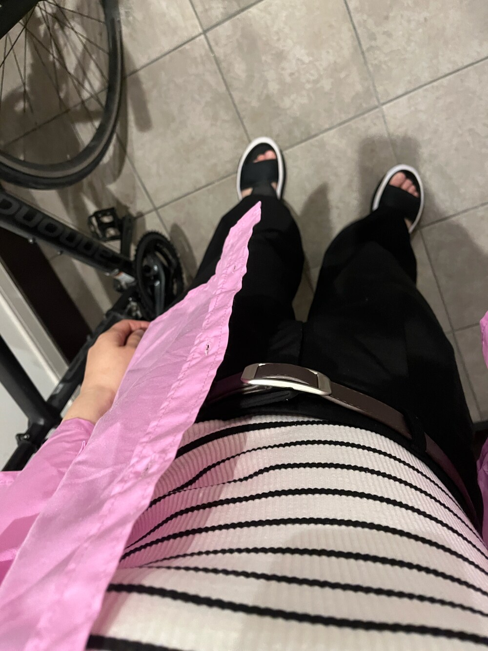 ブラック系のサンダル、ブラック系のスラックス、ホワイト系のキャミソールを着用したレディースの夏コーディネートの2枚目の写真