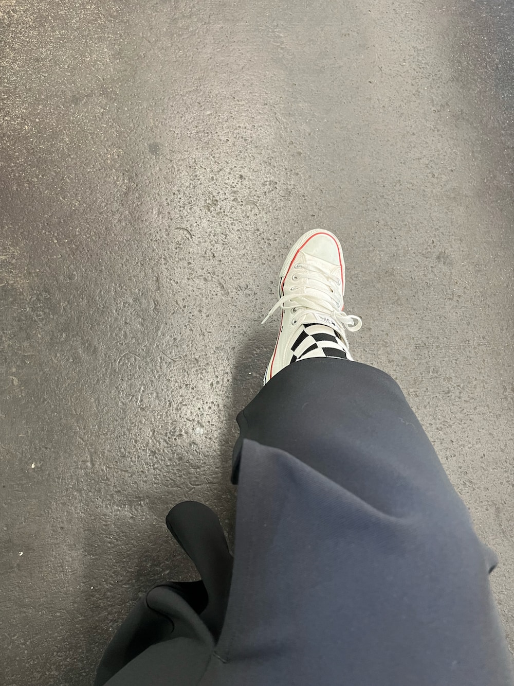 ホワイト系のスニーカー、ブラック系のスカート、ベージュ系のキャミソールを着用したレディースの夏コーディネートの2枚目の写真