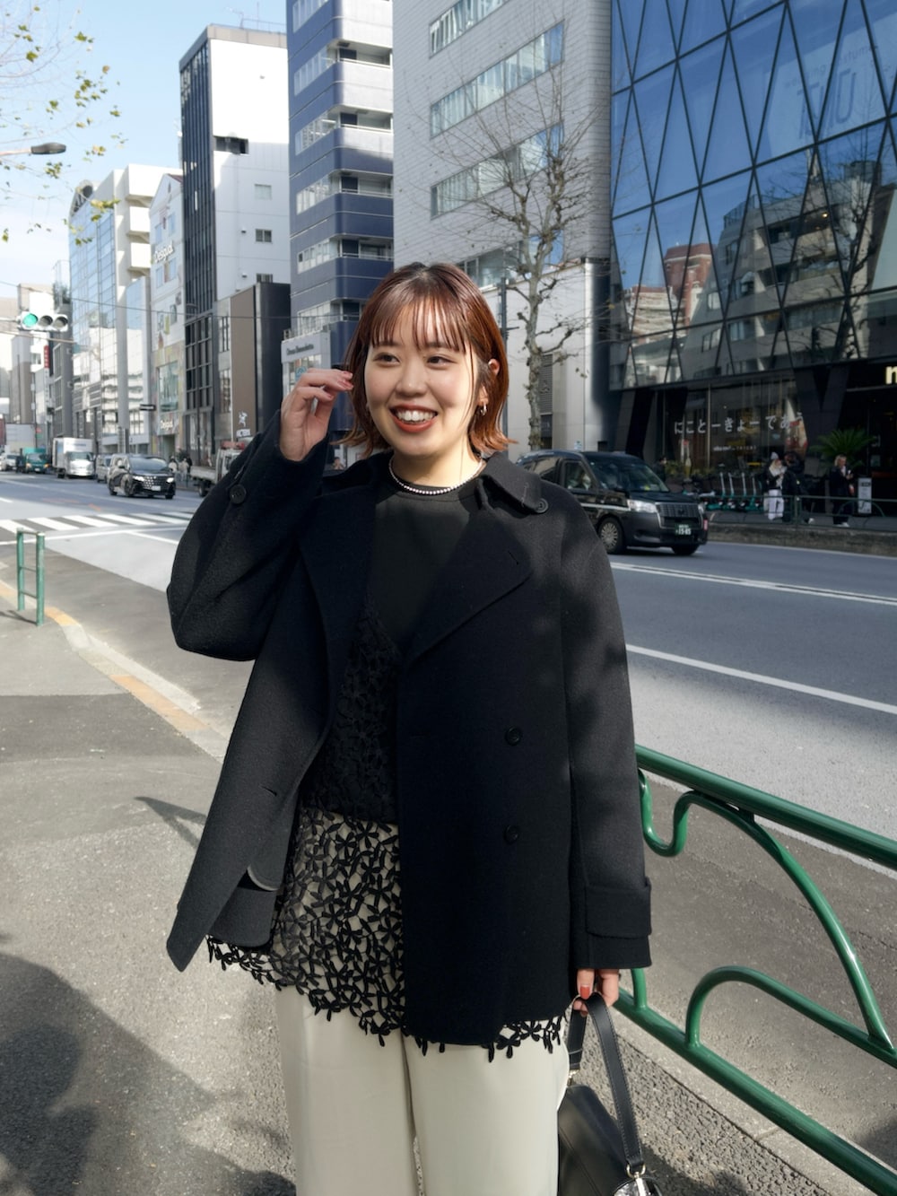 ブラック系のピーコート、ブラック系のキャミソール、ベージュ系のその他パンツを着用したレディースの冬コーディネートの5枚目の写真