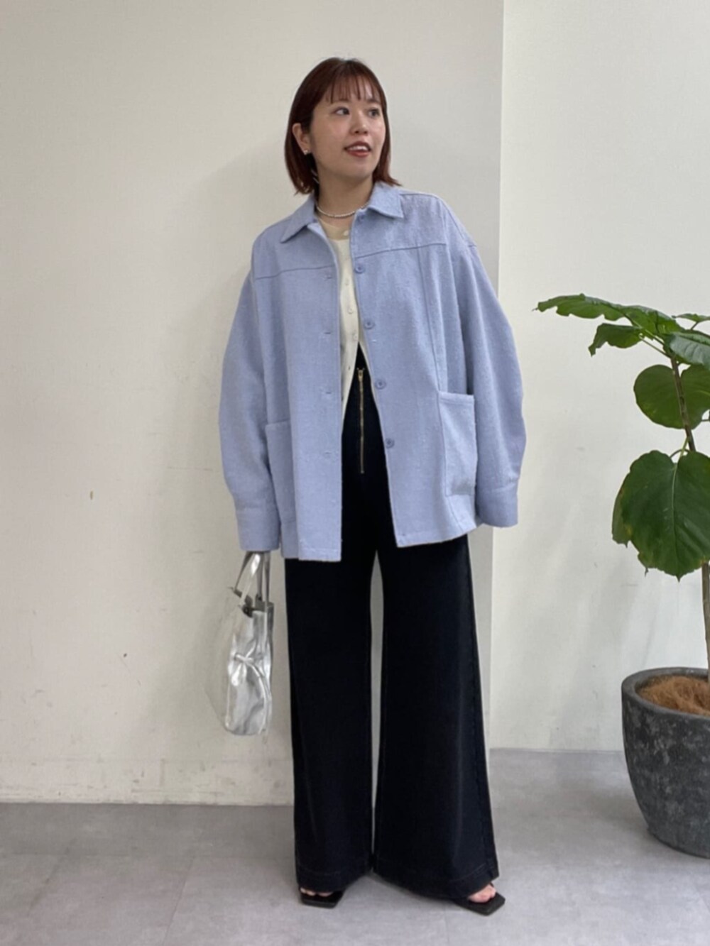 シルバー系のショルダーバッグ、グレー系のデニムパンツ、ブルー系のブルゾンを着用したレディースの春コーディネートの5枚目の写真