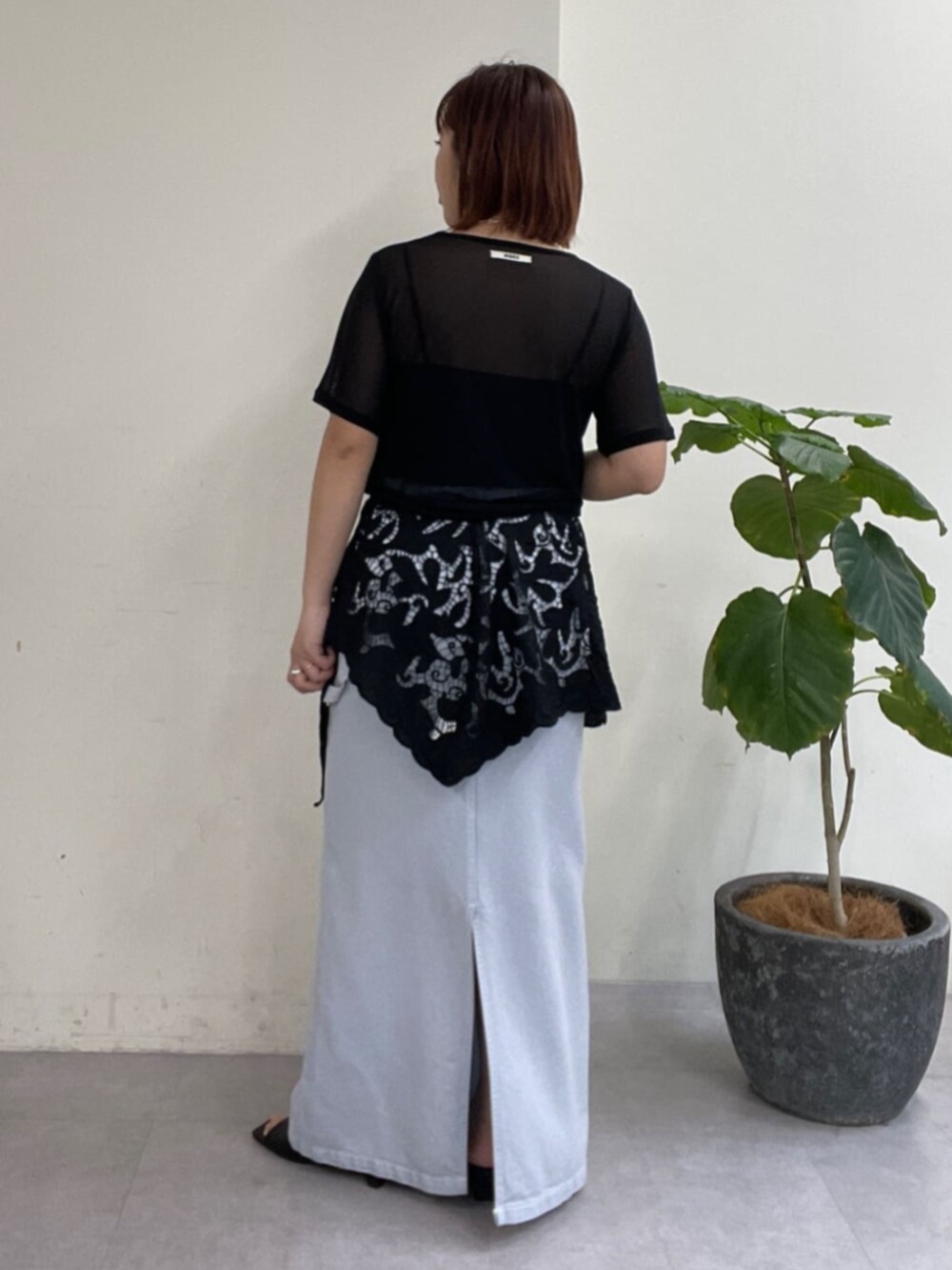 ブルー系のスカート、ブラック系のTシャツ/カットソー、ブラック系のサンダルを着用したレディースの春コーディネートの3枚目の写真