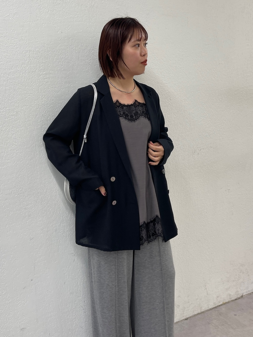 ブラック系のテーラードジャケット、ブラック系のキャミソール、グレー系のスウェットパンツを着用したレディースの冬コーディネートの5枚目の写真