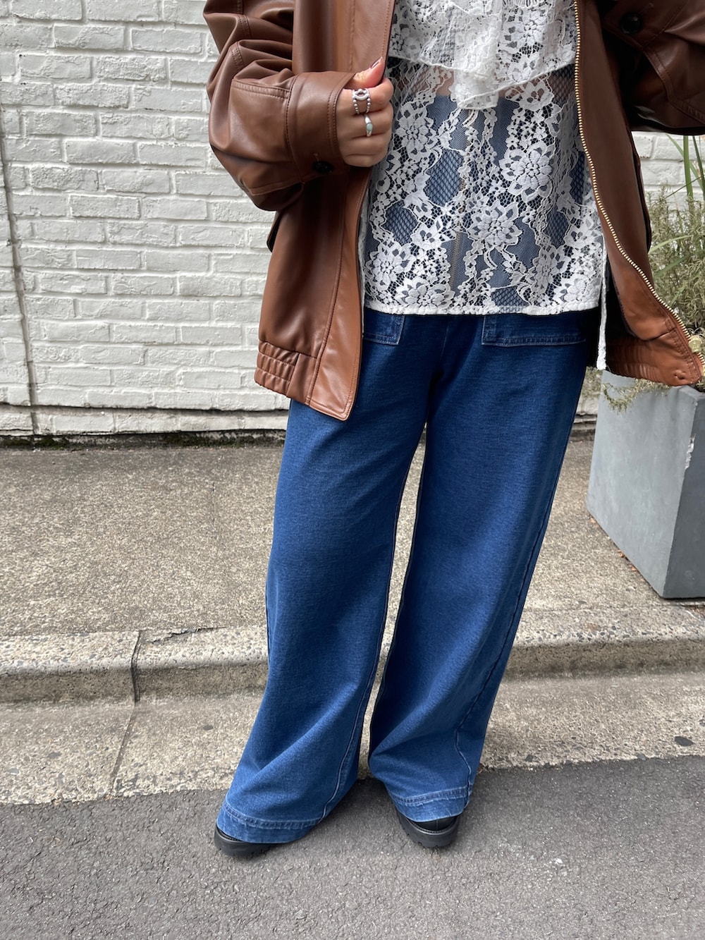 ブラウン系のブルゾン、ホワイト系のシャツ/ブラウス、ブルー系のデニムパンツを着用したレディースの冬コーディネートの6枚目の写真