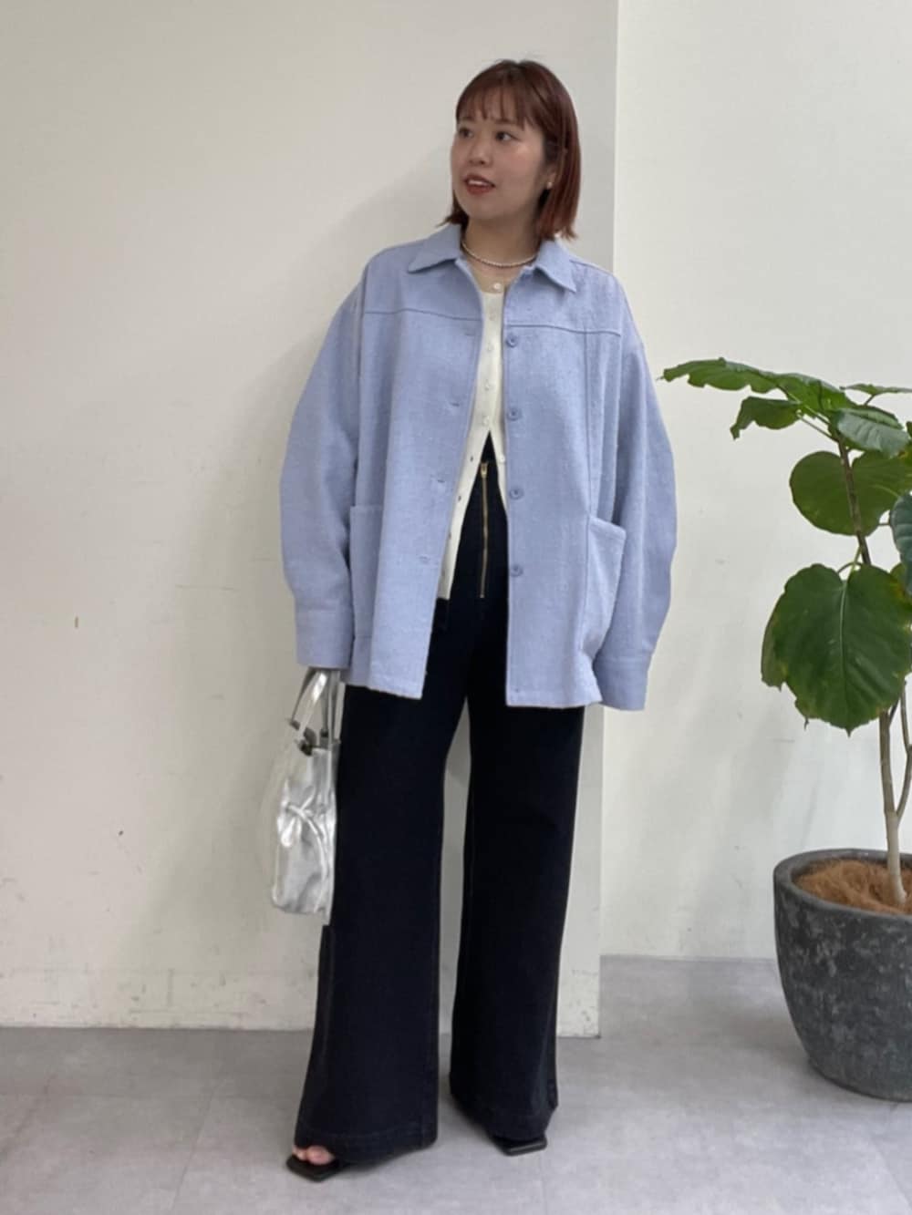 シルバー系のショルダーバッグ、グレー系のデニムパンツ、ブルー系のブルゾンを着用したレディースの春コーディネートの4枚目の写真