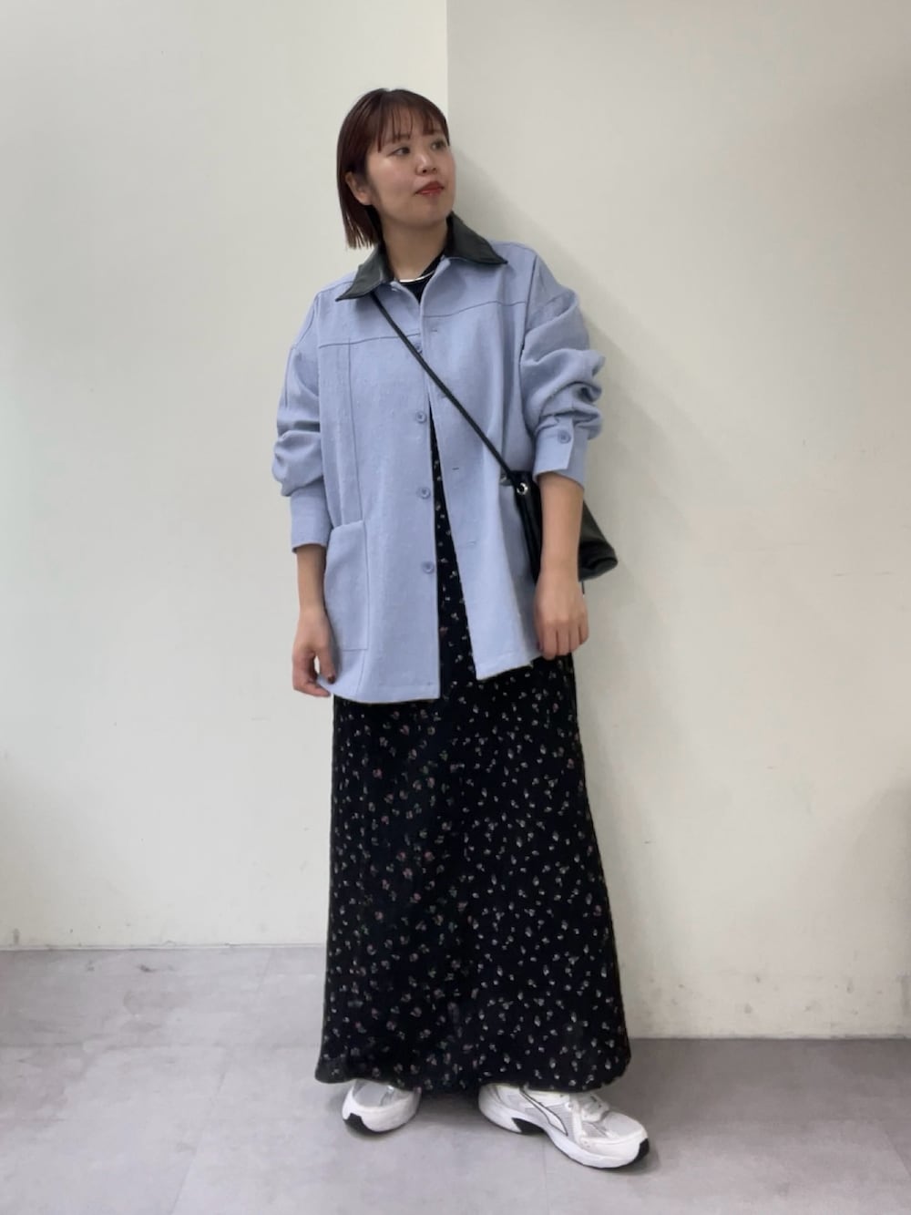 ブラック系のワンピース、ブラック系のトートバッグ、ブルー系のブルゾンを着用したレディースの冬コーディネートの3枚目の写真