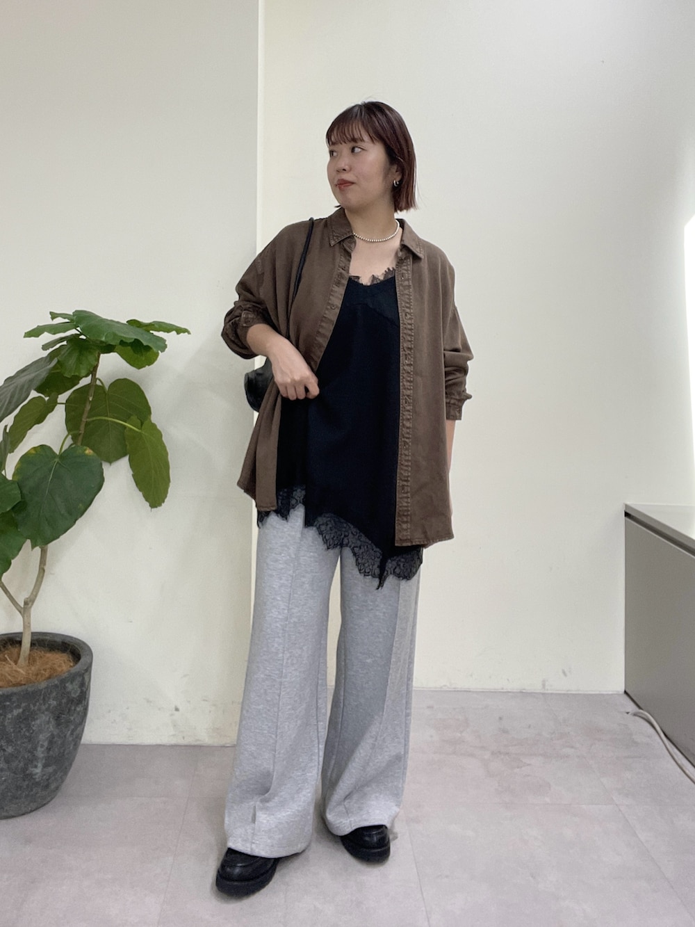 ブラウン系のシャツ/ブラウス、ブラック系のキャミソール、グレー系のその他パンツを着用したレディースの春コーディネートの7枚目の写真