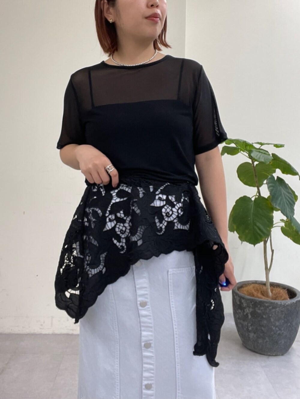 ブルー系のスカート、ブラック系のTシャツ/カットソー、ブラック系のサンダルを着用したレディースの春コーディネートの6枚目の写真