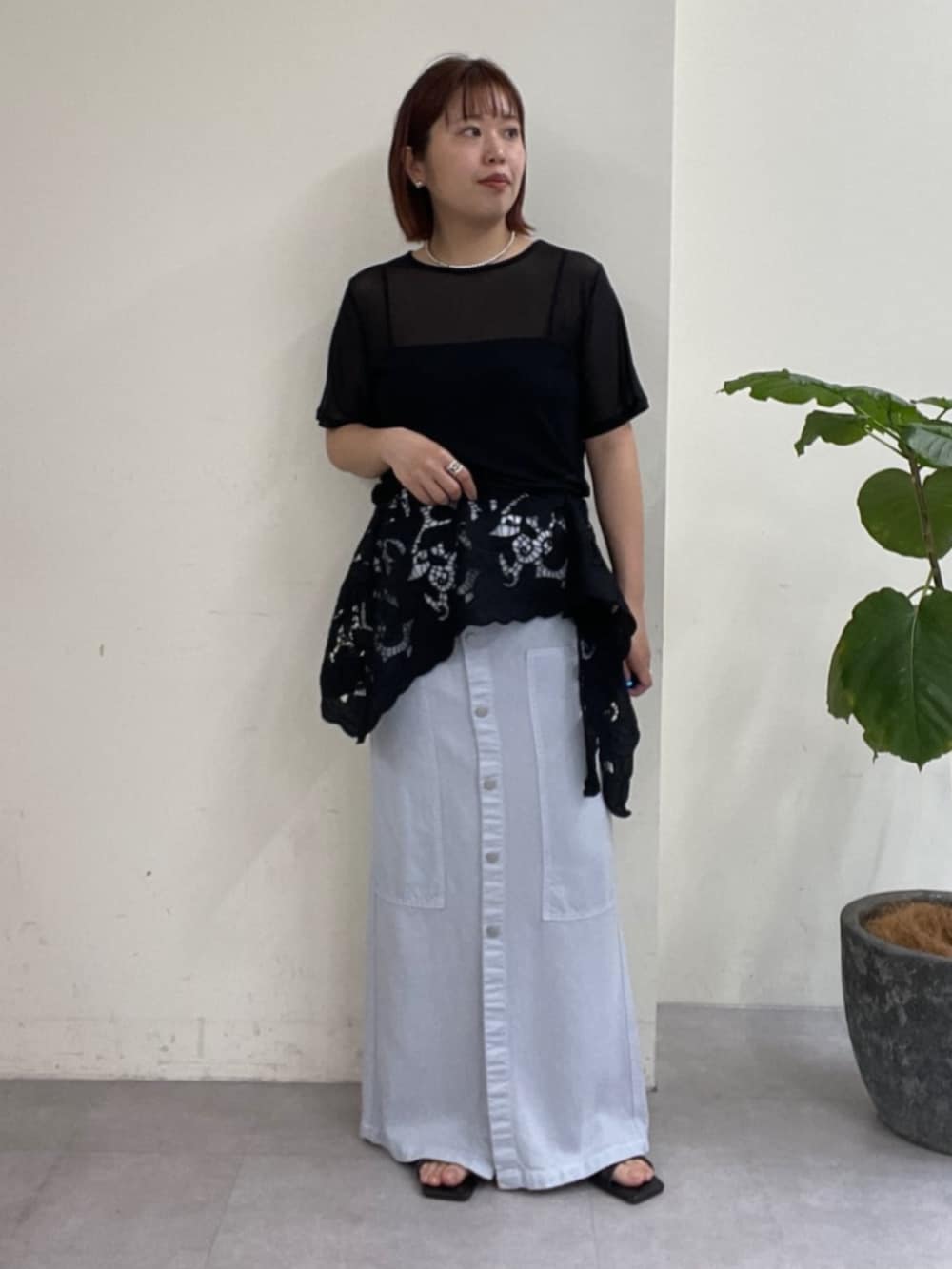 ブルー系のスカート、ブラック系のTシャツ/カットソー、ブラック系のサンダルを着用したレディースの春コーディネートの2枚目の写真