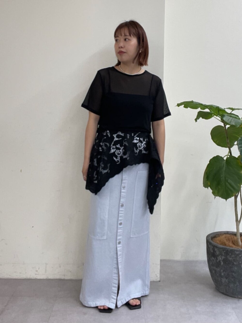 ブルー系のスカート、ブラック系のTシャツ/カットソー、ブラック系のサンダルを着用したレディースの春コーディネートの4枚目の写真