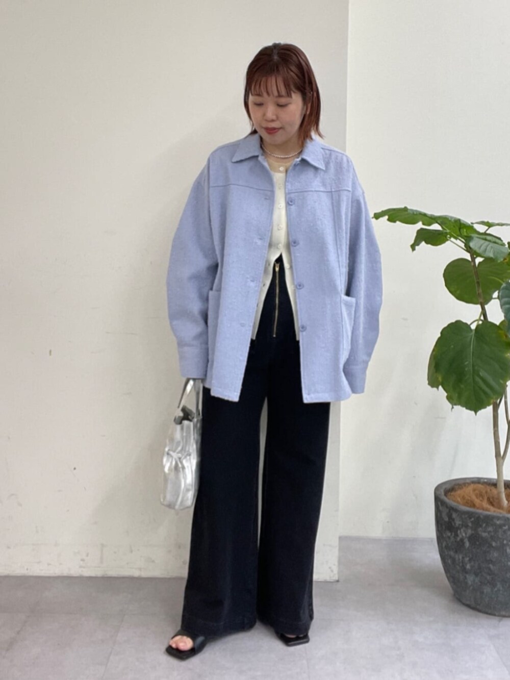シルバー系のショルダーバッグ、グレー系のデニムパンツ、ブルー系のブルゾンを着用したレディースの春コーディネートの2枚目の写真