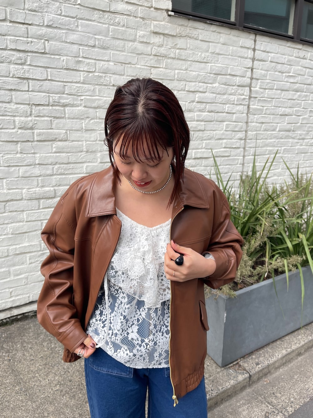 ブラウン系のブルゾン、ホワイト系のシャツ/ブラウス、ブルー系のデニムパンツを着用したレディースの冬コーディネートの5枚目の写真