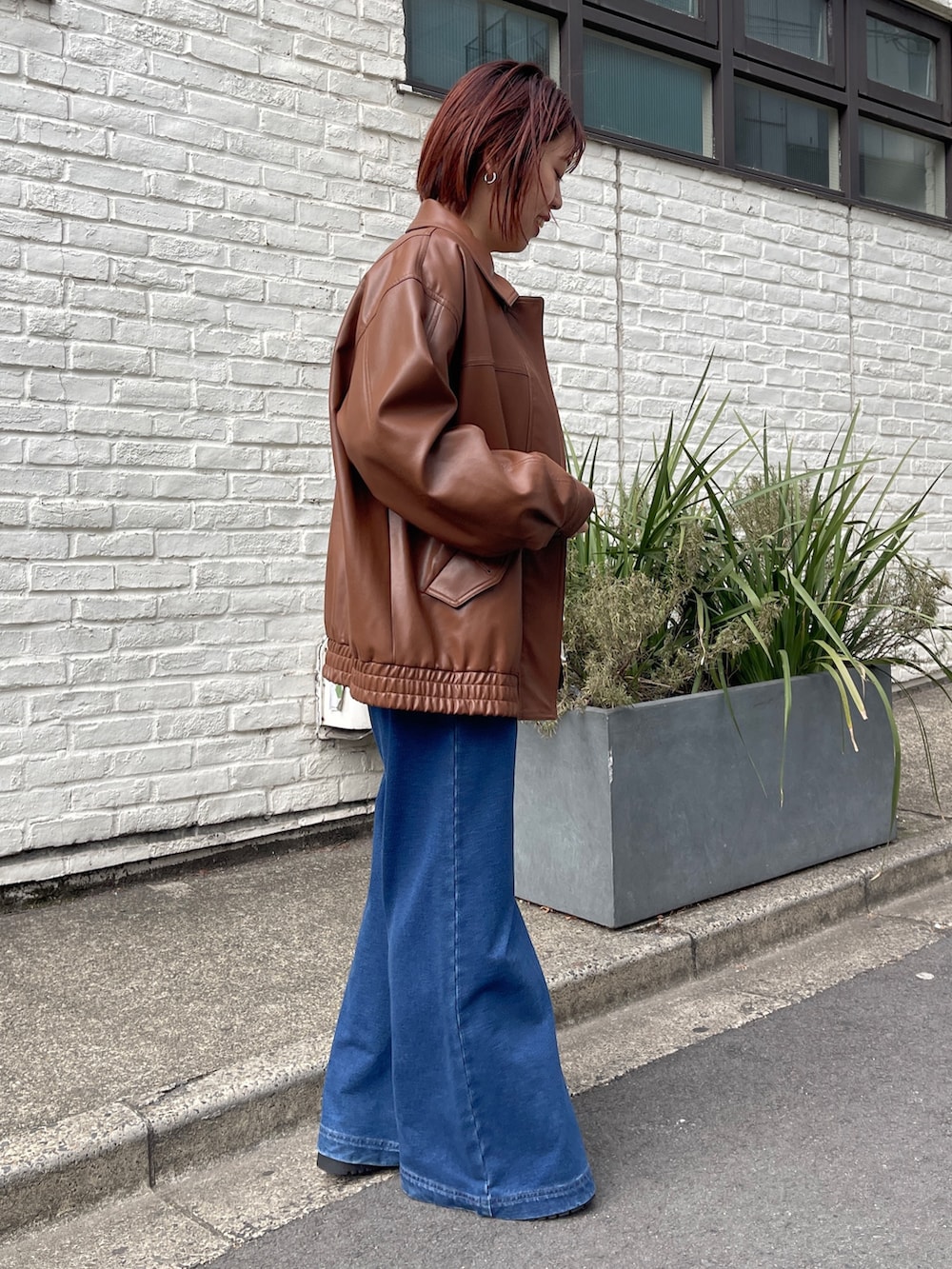 ブラウン系のブルゾン、ホワイト系のシャツ/ブラウス、ブルー系のデニムパンツを着用したレディースの冬コーディネートの3枚目の写真