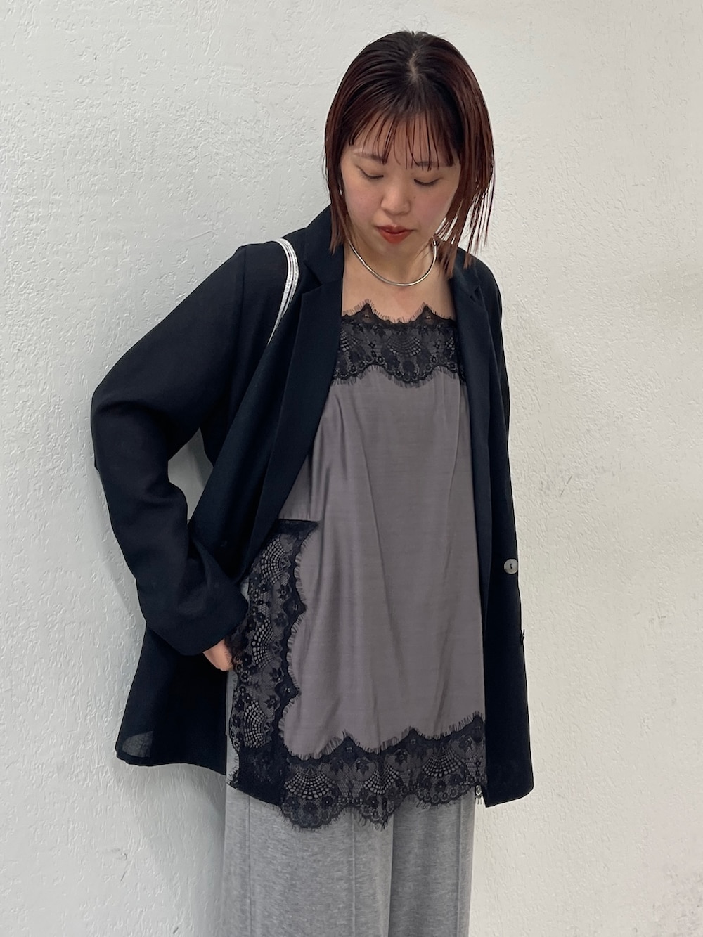 ブラック系のテーラードジャケット、ブラック系のキャミソール、グレー系のスウェットパンツを着用したレディースの冬コーディネートの4枚目の写真