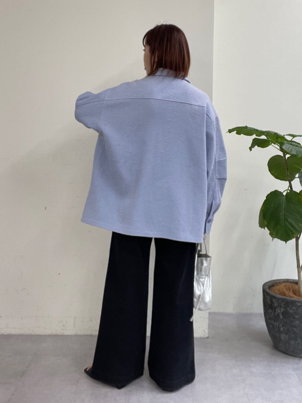 シルバー系のショルダーバッグ、グレー系のデニムパンツ、ブルー系のブルゾンを着用したレディースの春コーディネートの7枚目の写真
