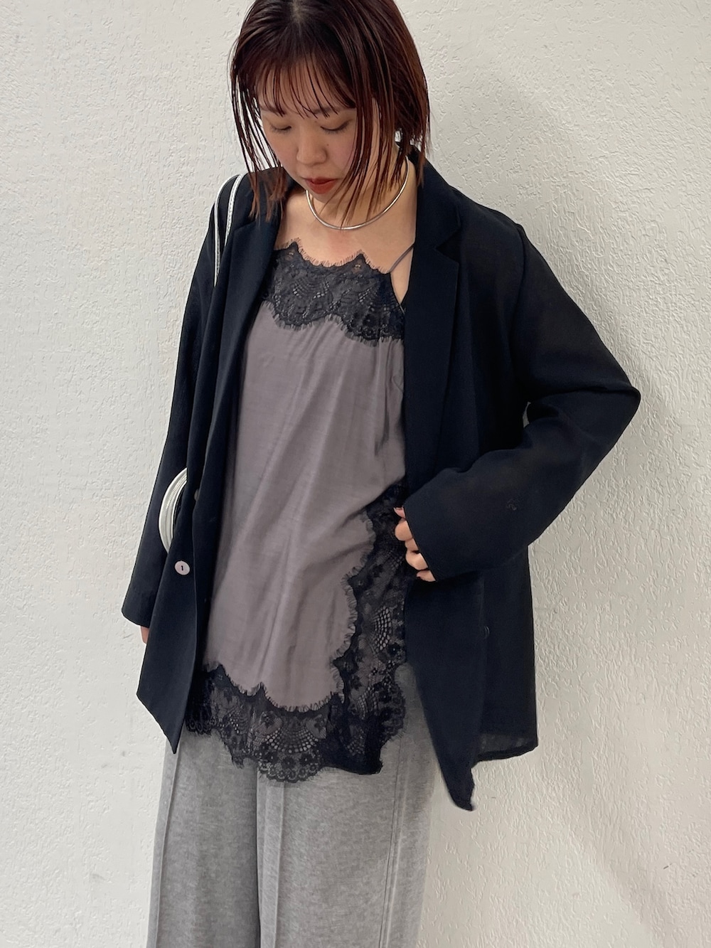 ブラック系のテーラードジャケット、ブラック系のキャミソール、グレー系のスウェットパンツを着用したレディースの冬コーディネートの3枚目の写真