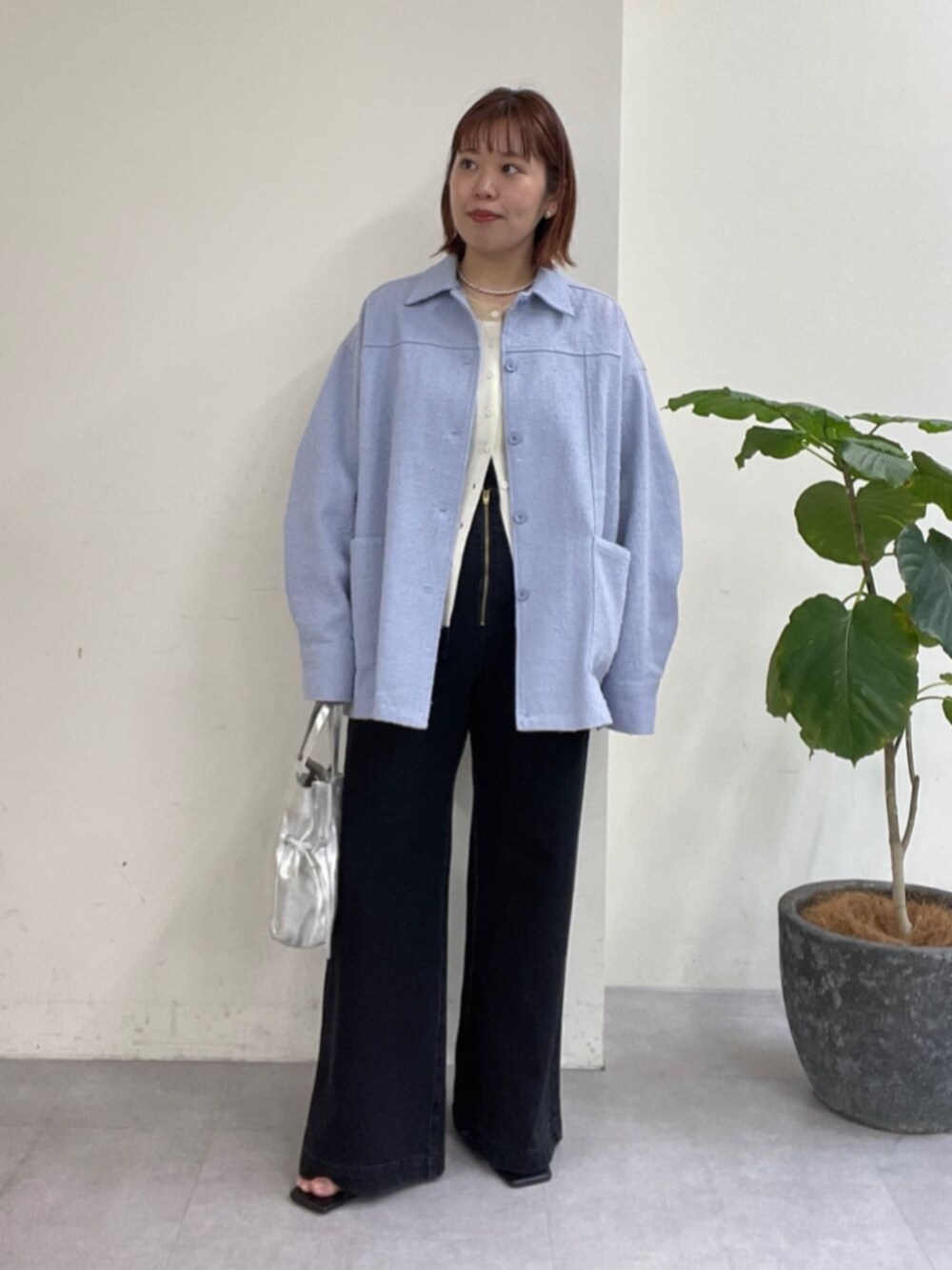 シルバー系のショルダーバッグ、グレー系のデニムパンツ、ブルー系のブルゾンを着用したレディースの春コーディネートの3枚目の写真