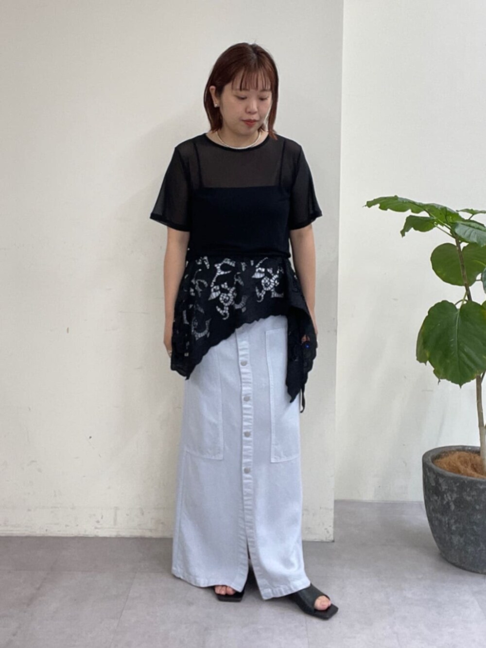 ブルー系のスカート、ブラック系のTシャツ/カットソー、ブラック系のサンダルを着用したレディースの春コーディネートの5枚目の写真