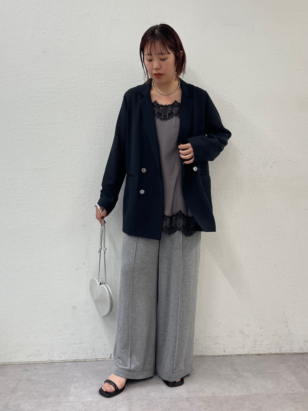 ブラック系のテーラードジャケット、ブラック系のキャミソール、グレー系のスウェットパンツを着用したレディースの冬コーディネートの2枚目の写真