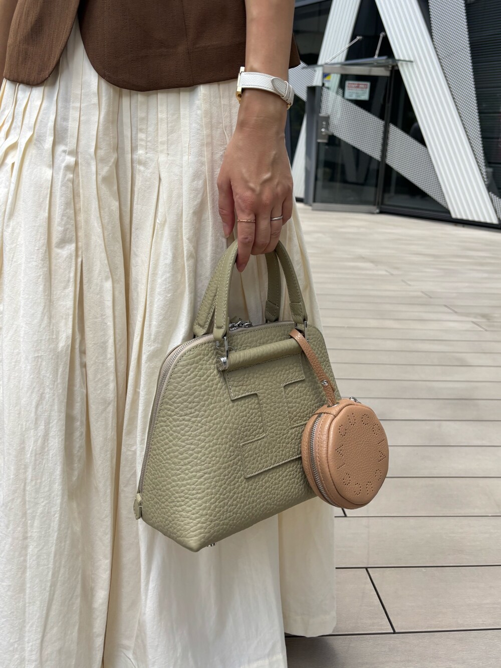 グリーン系のボストンバッグ、イエロー系のその他小物を着用したレディースの夏コーディネートの2枚目の写真