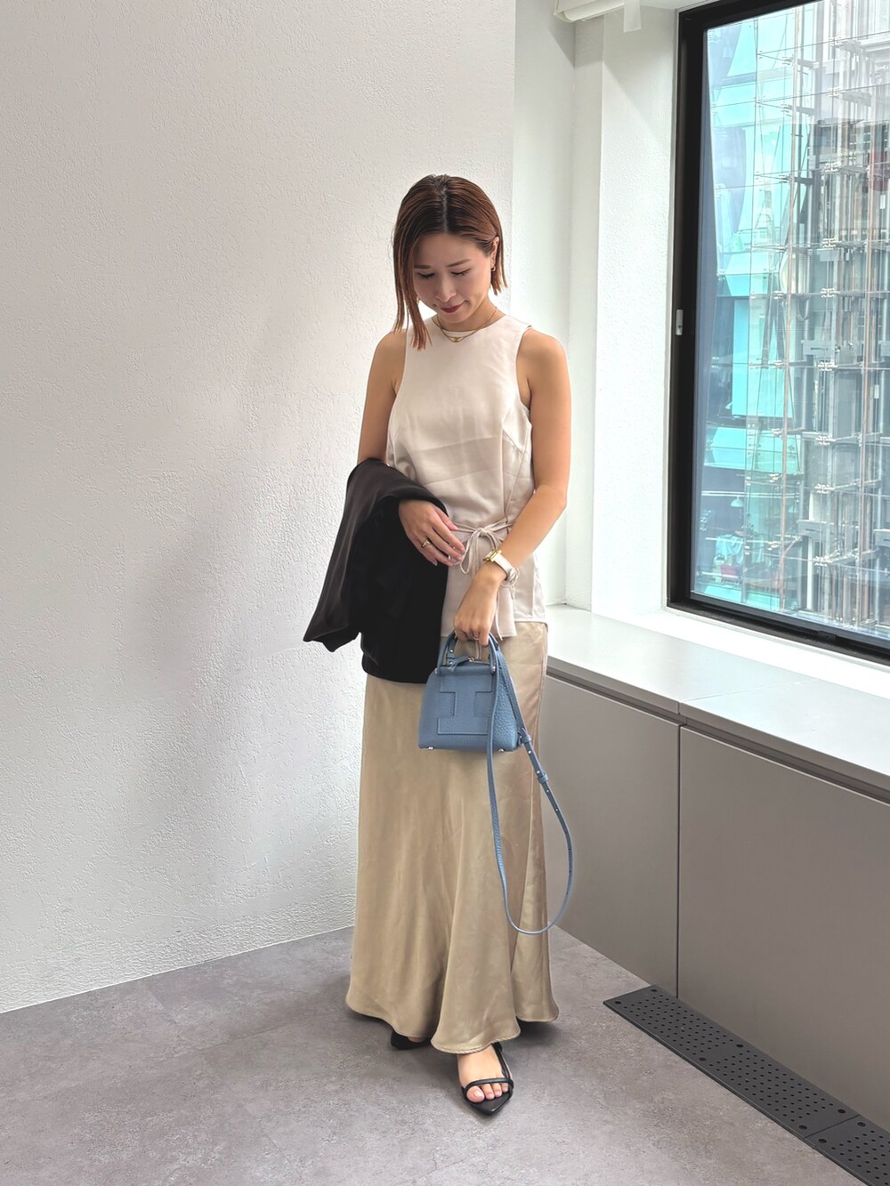 ブルー系のトートバッグを着用したレディースの秋コーディネートの2枚目の写真