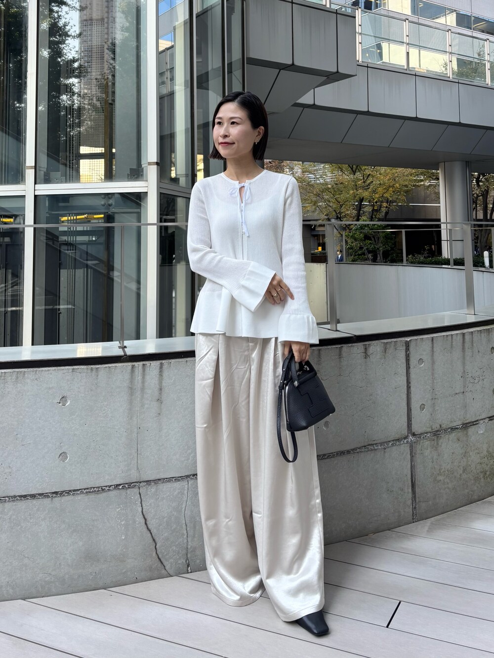 ブラック系のトートバッグを着用したレディースの秋コーディネートの3枚目の写真