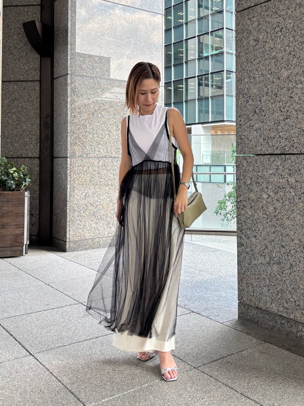 グリーン系のショルダーバッグを着用したレディースの夏コーディネートの2枚目の写真