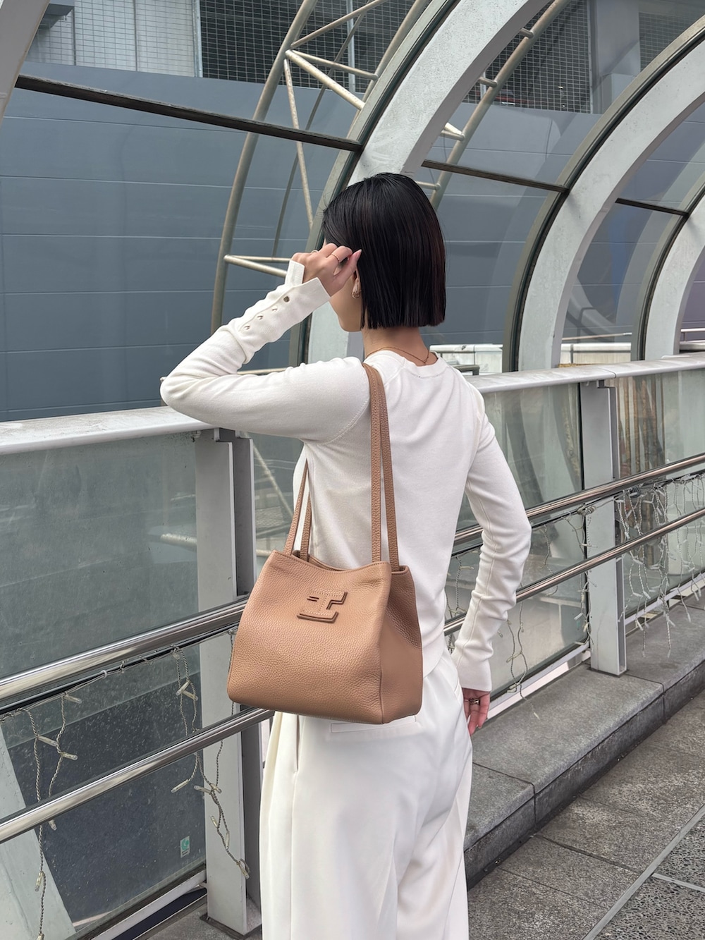 イエロー系のトートバッグを着用したレディースの冬コーディネートの2枚目の写真