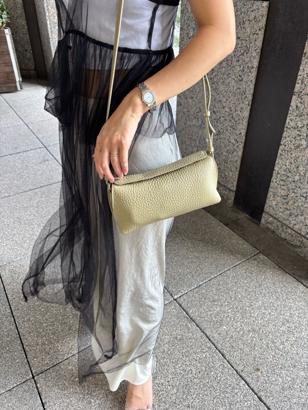 グリーン系のショルダーバッグを着用したレディースの夏コーディネートの3枚目の写真