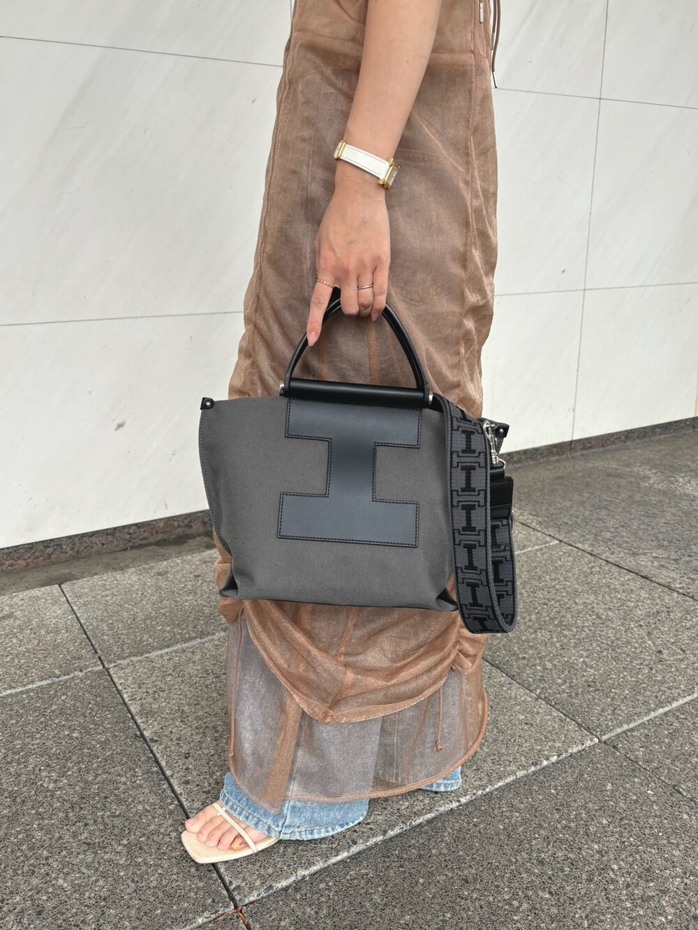 グレー系のトートバッグ、グレー系のその他小物を着用したレディースの夏コーディネートの3枚目の写真