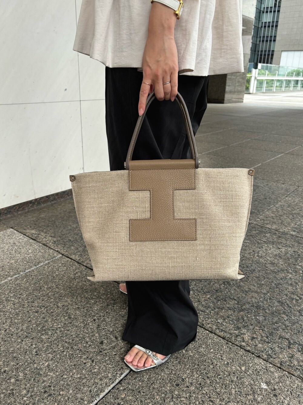 ベージュ系のトートバッグを着用したレディースの夏コーディネートの2枚目の写真