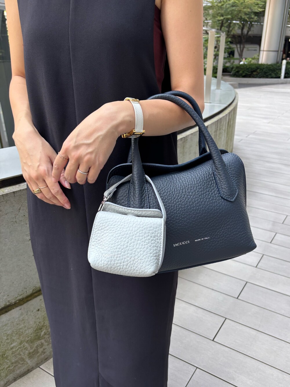 ブルー系のショルダーバッグ、グレー系のその他小物を着用したレディースの夏コーディネートの2枚目の写真