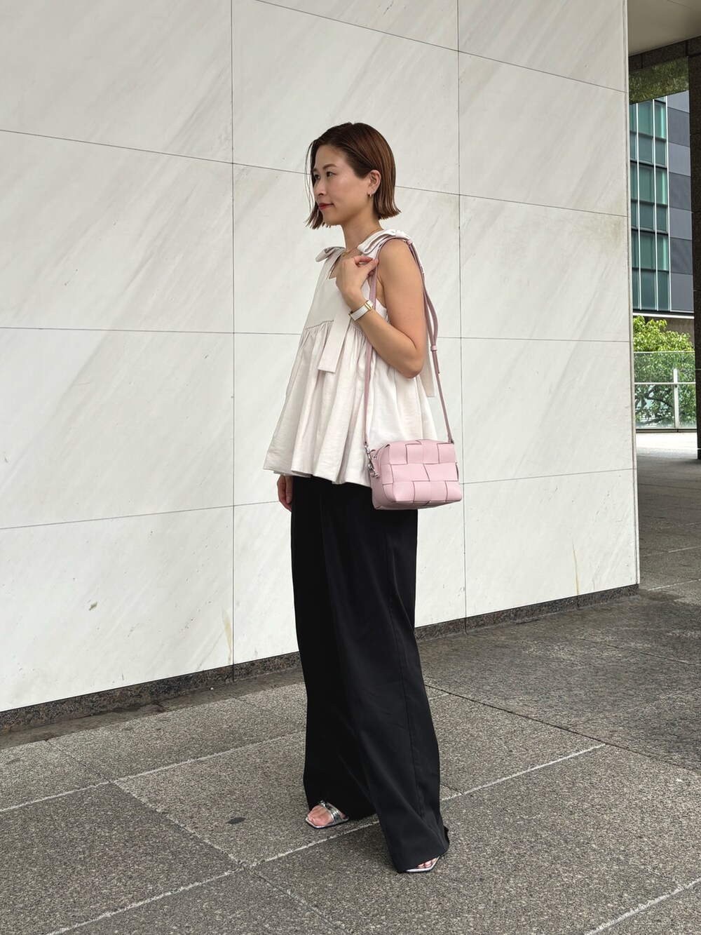 ピンク系のショルダーバッグを着用したレディースの秋コーディネートの2枚目の写真