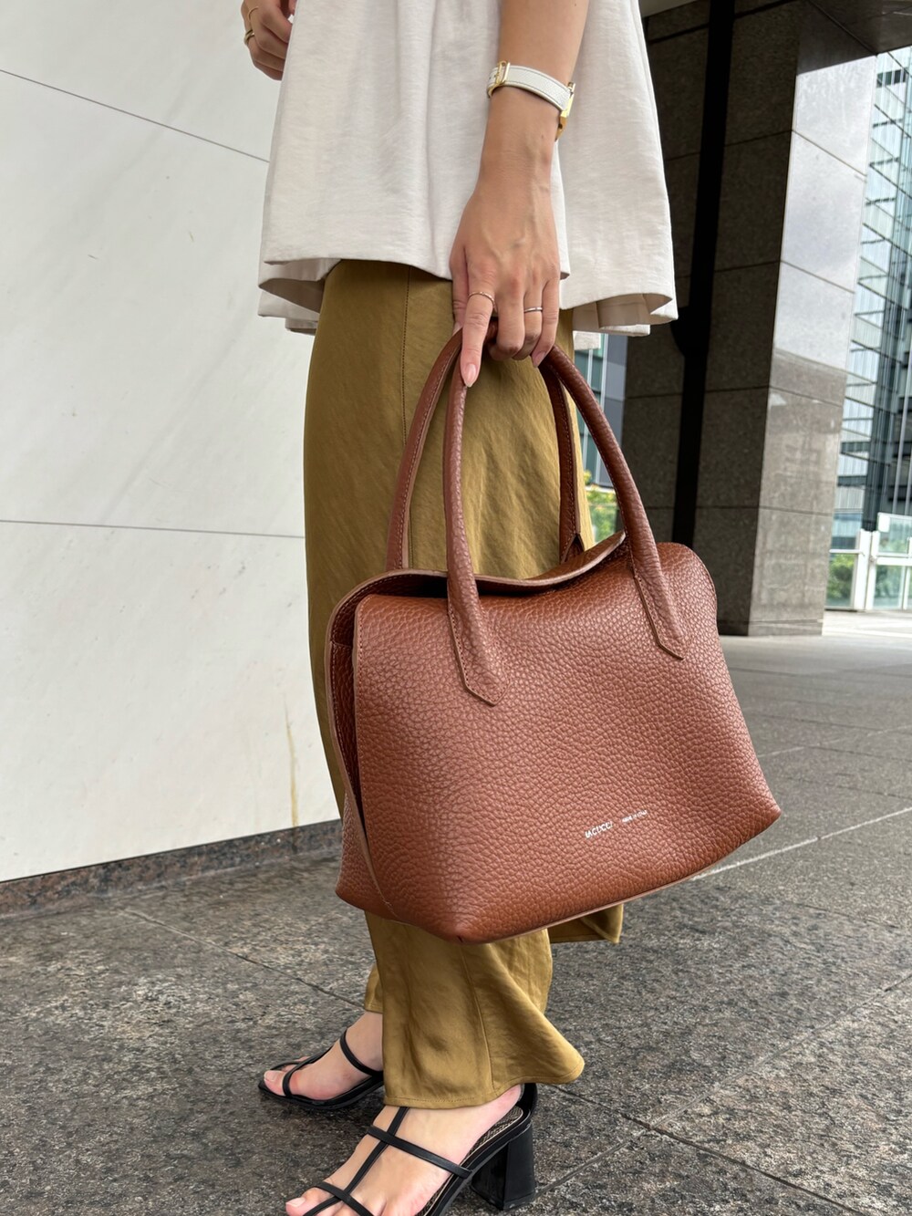 ブラウン系のトートバッグを着用したレディースの夏コーディネートの2枚目の写真