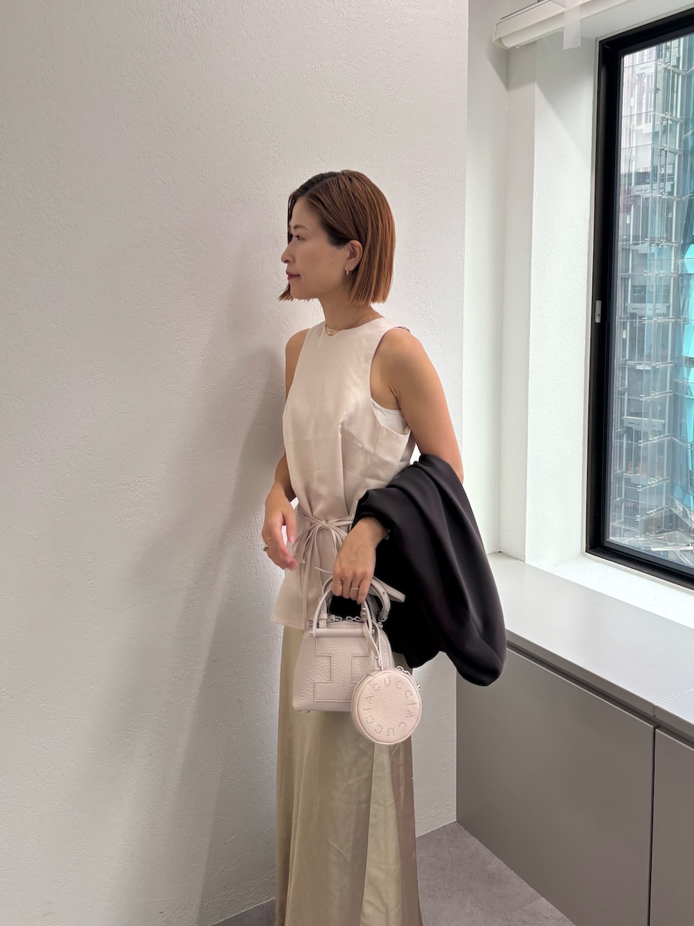 ホワイト系のトートバッグを着用したレディースの秋コーディネートの2枚目の写真