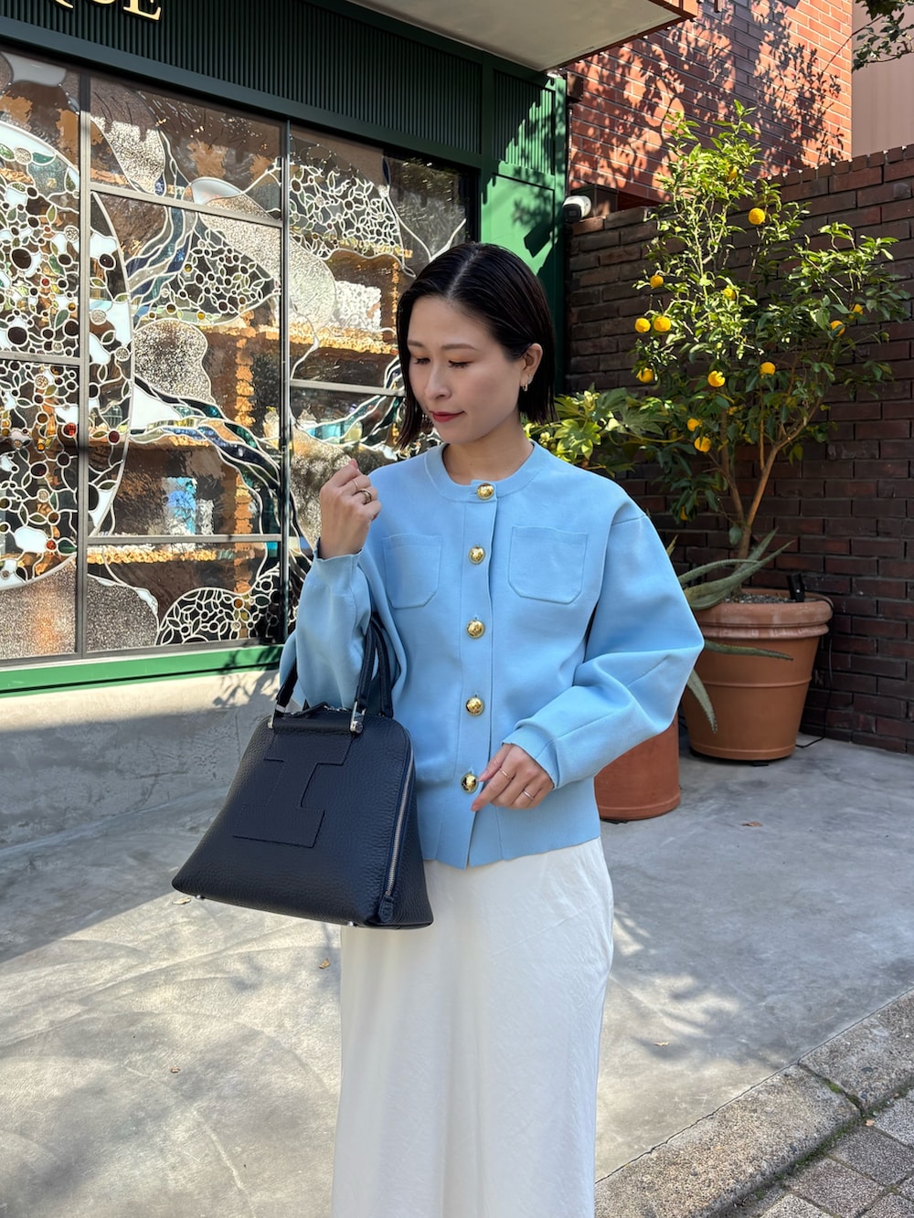 ブルー系のボストンバッグを着用したレディースの冬コーディネートの2枚目の写真