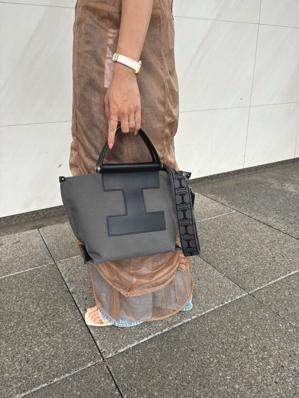 グレー系のトートバッグ、グレー系のその他小物を着用したレディースの夏コーディネートの4枚目の写真