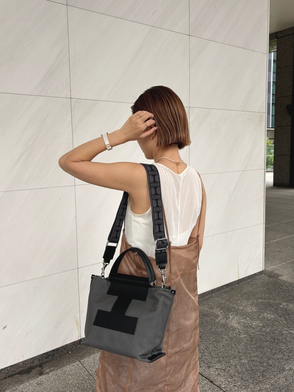 グレー系のトートバッグ、グレー系のその他小物を着用したレディースの夏コーディネートの2枚目の写真
