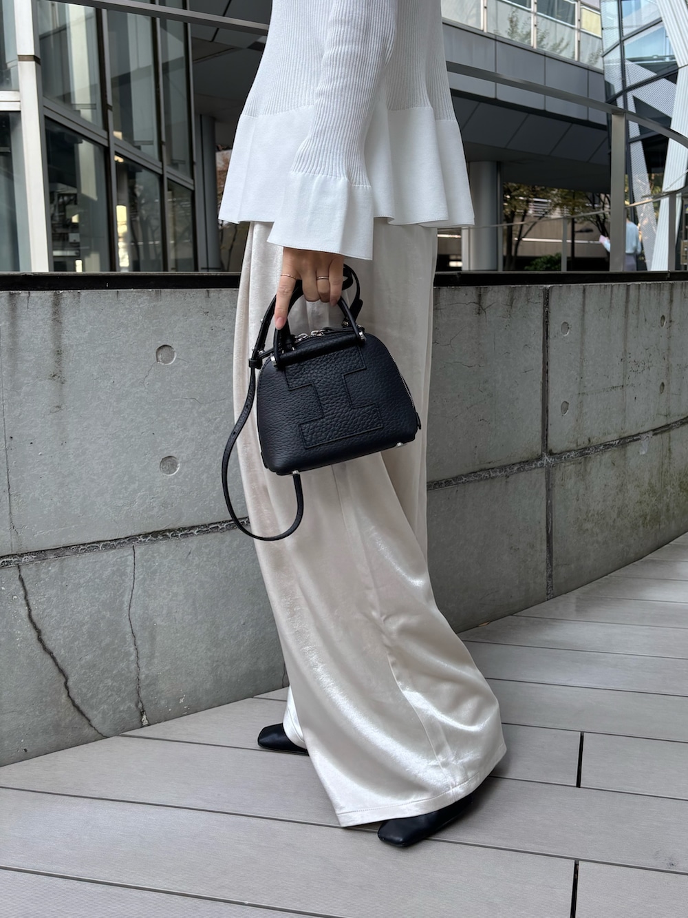 ブラック系のトートバッグを着用したレディースの秋コーディネートの2枚目の写真