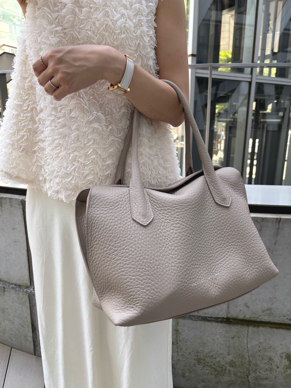 ベージュ系のトートバッグを着用したレディースの夏コーディネートの2枚目の写真