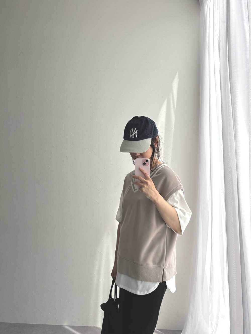 ベージュ系のスウェット、ブラック系のスカート、ホワイト系のスニーカーを着用したレディースの春コーディネートの2枚目の写真